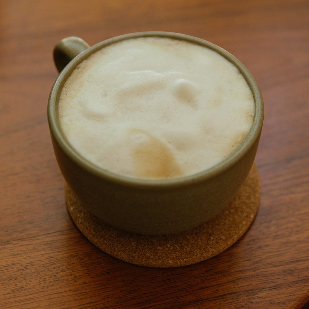 Latte in a green ceramic cup at OLIVO